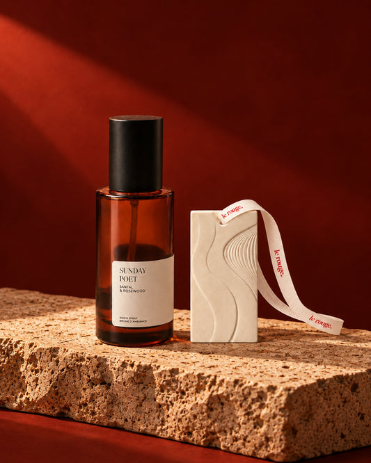 Sunday Poet room spray and WAVE ornament duo styled on stone with a red backdrop