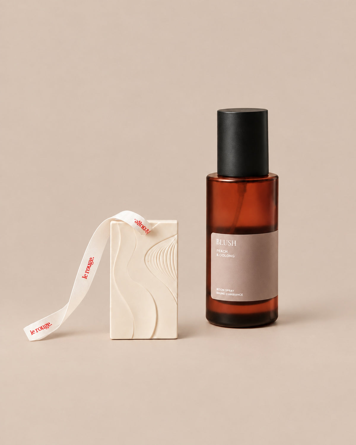 Blush room spray and WAVE ornament duo on a plain beige background