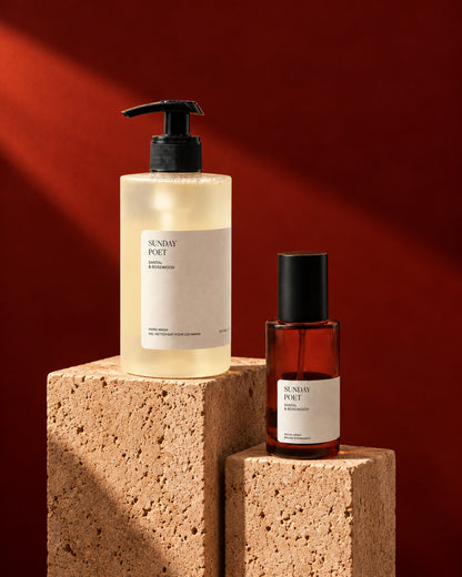 Sunday Poet hand wash and room spray duo styled on stone with a red backdrop