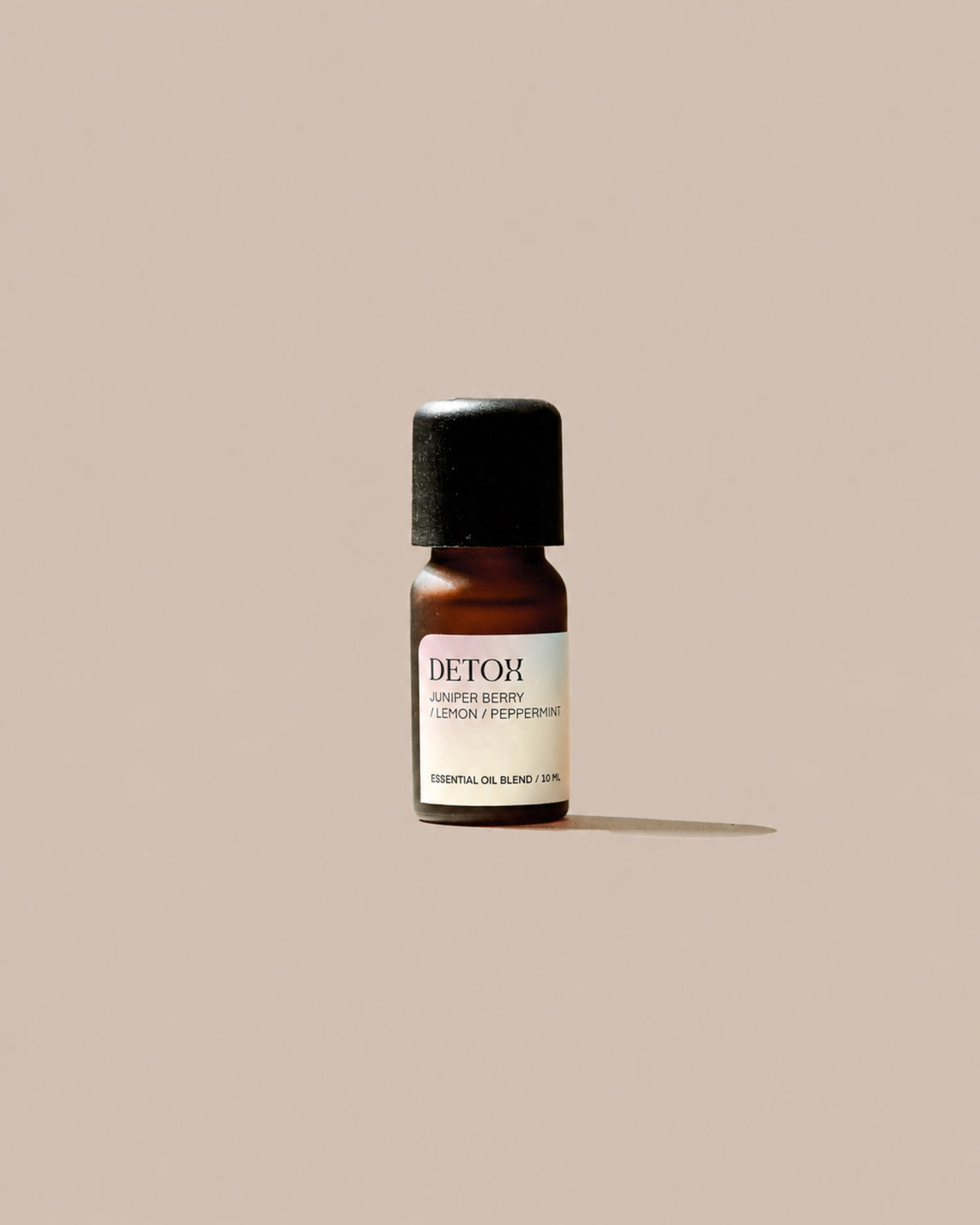 DETOX Essential Oil Blend 10ml with pale patterned label on a clean beige background.