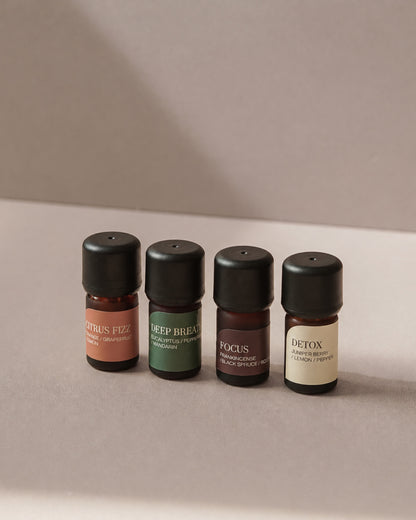 Citrus Fizz, Deep Breath, Focus and Detox diffuser blends, four 5ml bottles on a warm beige tabletop.