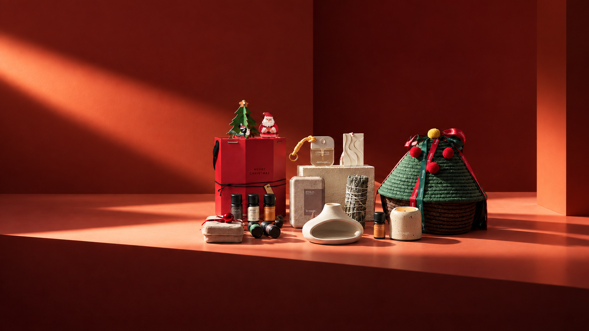 Le Rouge holiday fragrance gifts arranged against a warm red backdrop